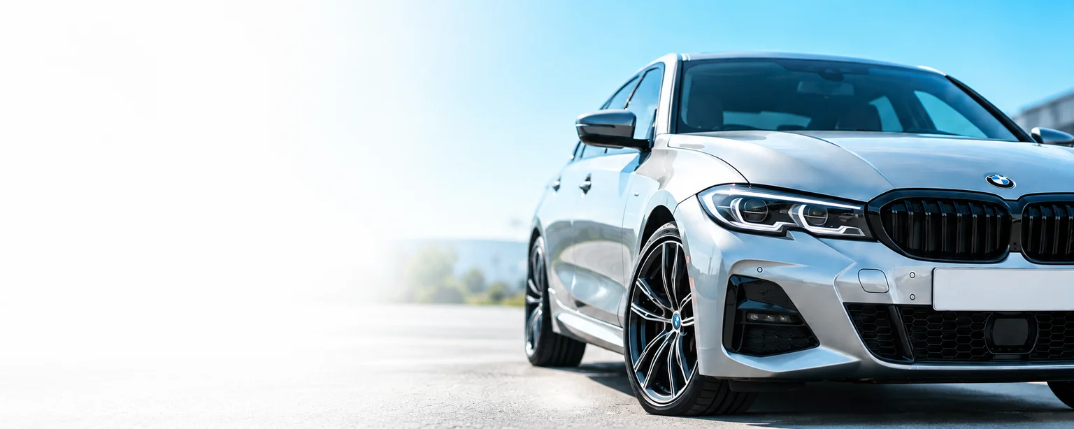 Silver BMW in a bright dealership forecourt